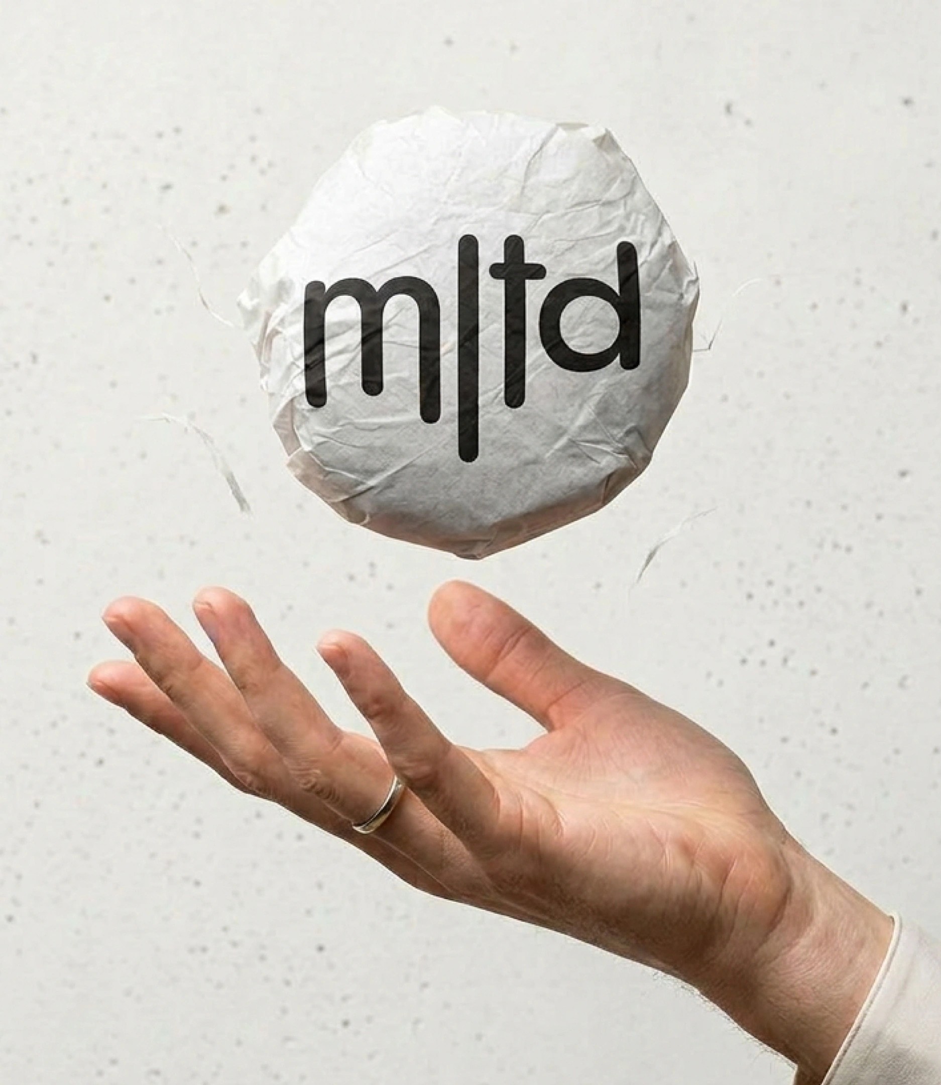 a crumpled wrapper with the short 'mltd' mark tossed from a hand