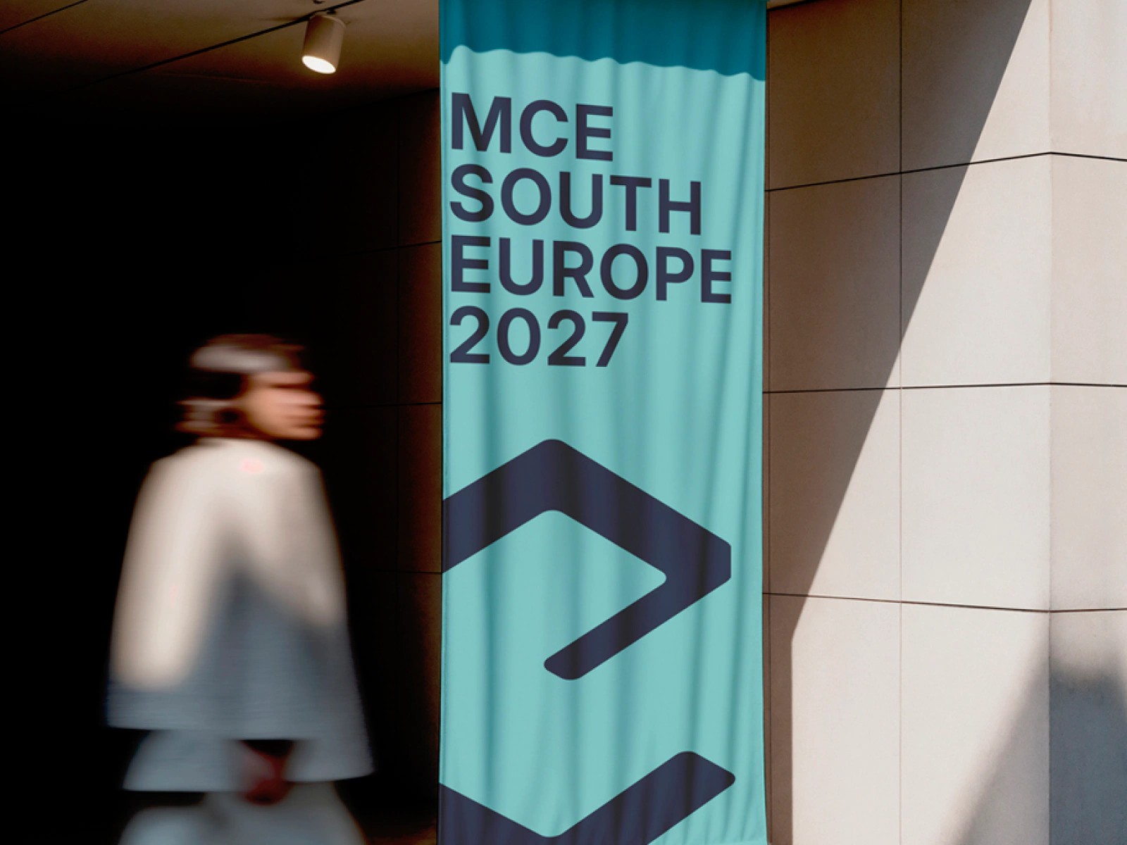 Events Club banner for MCE South Europe 2027 hanging on a building, a person walking past